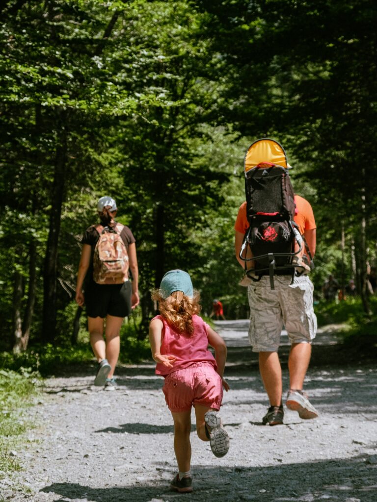 A child hiking trekking with parents outdoors woods