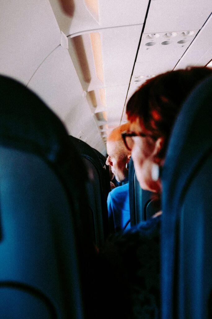 Passengers inside an airplane looking out the window - Budget Travel Tips