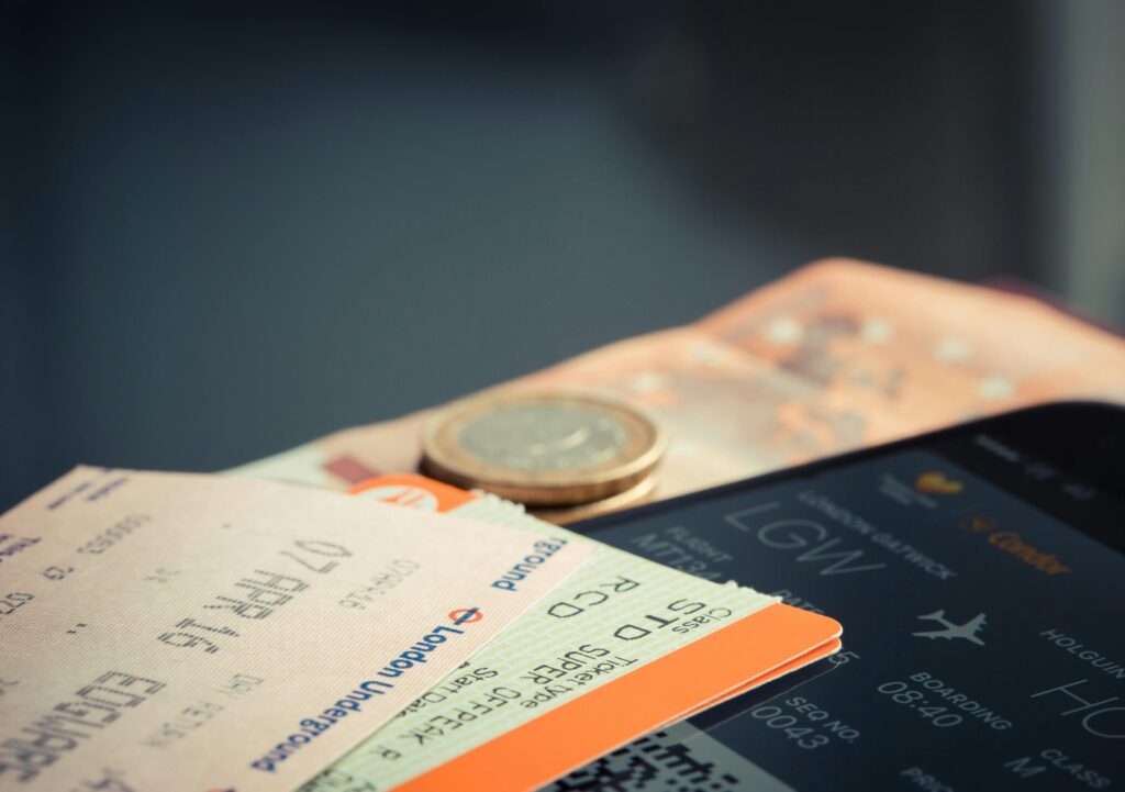 Track Cheap Flights - a photo of a coin money and different airline tickets and a mobile phone