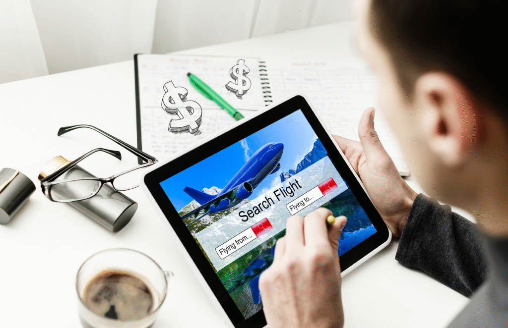 Track Cheap Flights - A young man holding a mobile tablet and looking at a flight booking site to compare prices