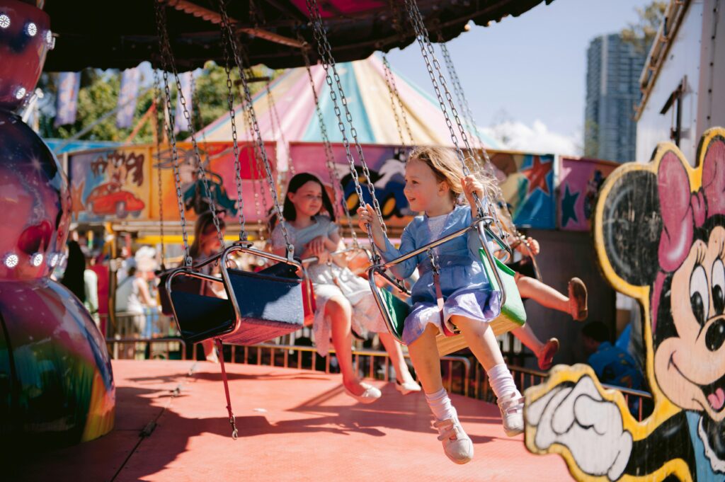 Kids riding on rides in an amusement park