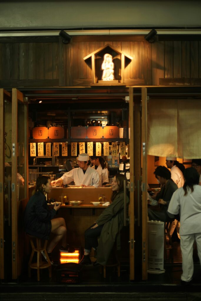 Cheap Travel Food Tips - Budget Friendly Restaurants - Food diners enjoying their meal in a small Asian restaurant