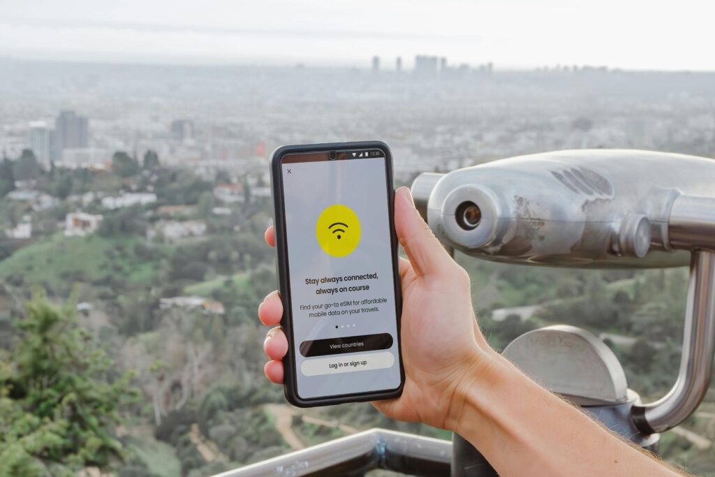 Traveletty - Best Free Travel Apps - A hand holding a phone with a WiFi logo on it