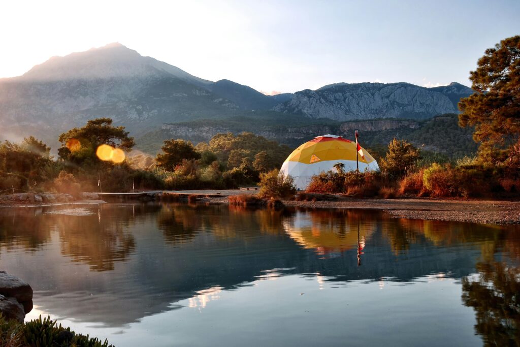 Traveletty - Bubble Domes - A scenic image of a bubble dome tent hotel by the mountain lake