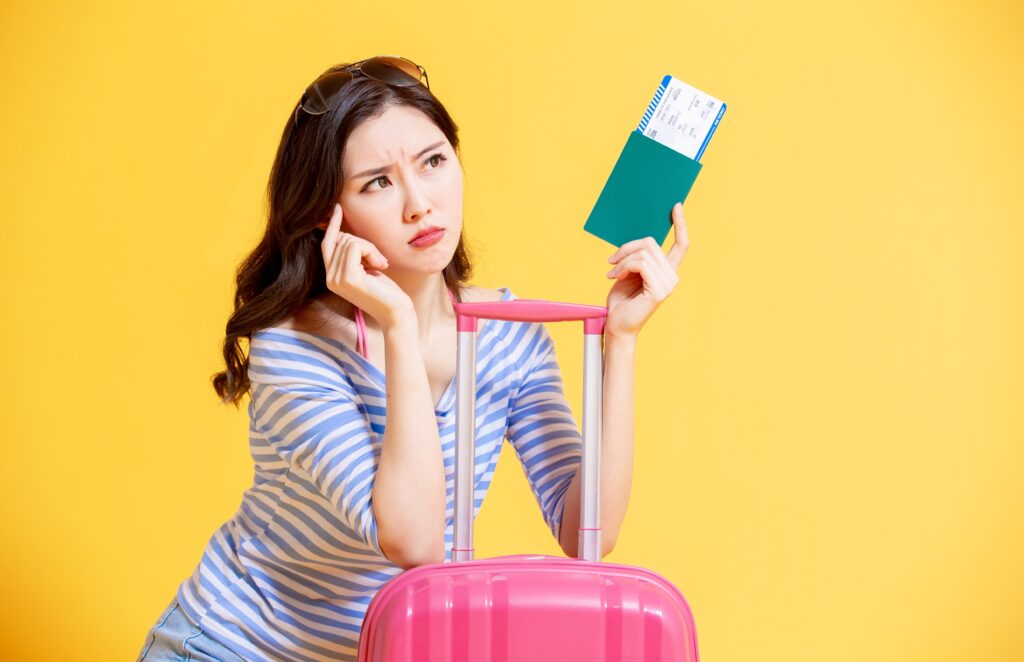 Traveletty - Common Travel Scams - young female traveler looking upset 