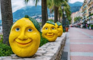 Traveletty - Free Local Events and Festivals - Featured Image - Bright yellow lemons stand on display during the Menton Lemon Festival