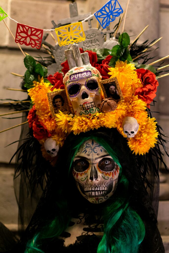 Traveletty - Free Local Events and Festivals - A woman wearing a skeleton costume with flowers on her head during a festival in Mexico