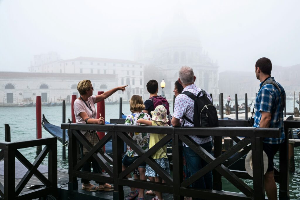 Traveletty - Free Walking Tours - A free walking tour guide talking to a group of tourists standing on wooden dock in a port