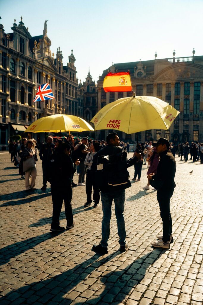 Traveletty - Free Walking Tours - Free tour guides holding yellow umbrellas talking to tourists