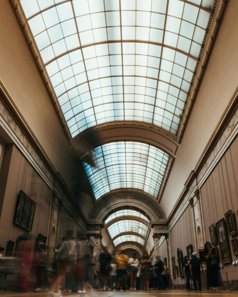 Traveletty - Museums and Art Galleries - A crowded hallway of an art gallery with skylight ceiling