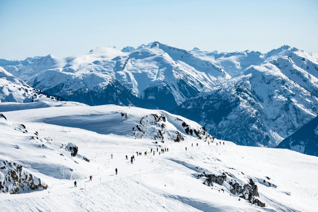 Traveletty - Ski Resorts - people walking on snow covered mountains in a ski resort