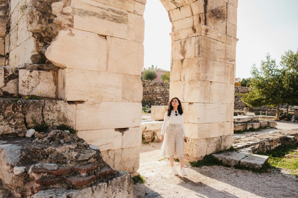 Traveletty - Solo Female Travel Safety - a solo female tourist wearing with a curly hair walking at ancient ruins site