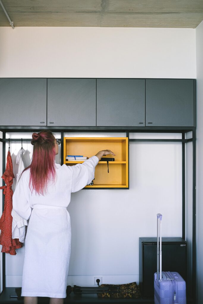 Traveletty - Solo Female Travel Safety - A solo female traveler checking her belongings in the hotel closet