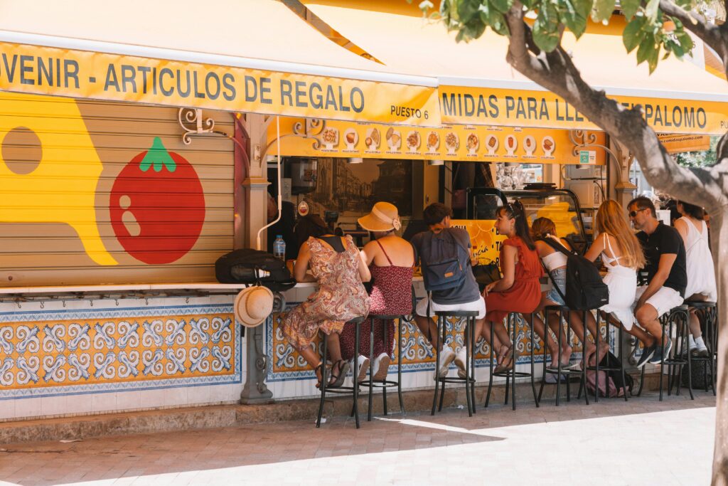 A traveler browsing gift items and local goods at a shop in a Spanish-speaking destination, highlighting the importance of supporting safe and reputable local commerce as part of travel health and safety.