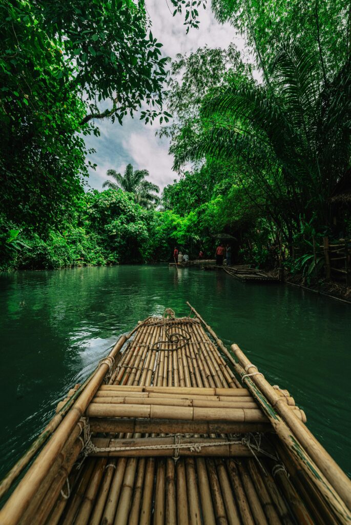 Traveletty - Floating Cabins - bamboo raft activity in lush river