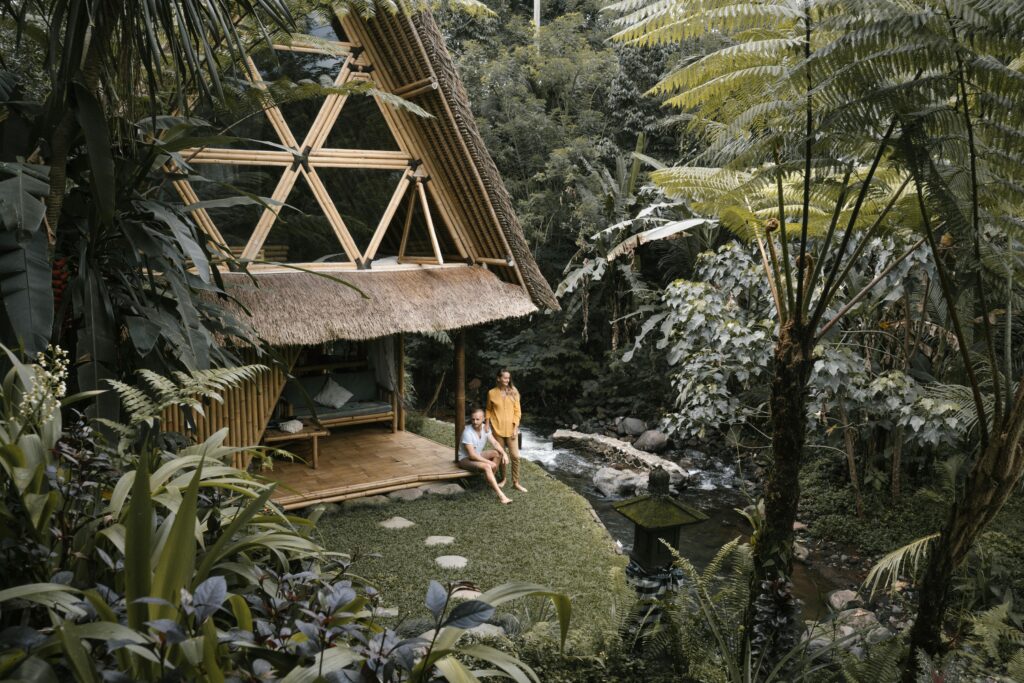 Traveletty - Jungle Huts - tourist couple spending vacation in a bamboo house in the forest