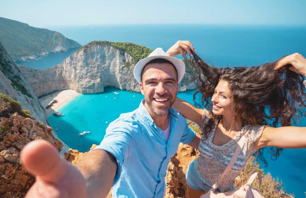 Traveletty - Romantic Travel Destinations - Couple taking a playful selfie at the top of a hill while on a vacation